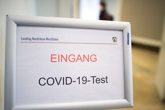 Ein Schild weist auf den Eingang zu einem Covid-19-Testcenter hin.