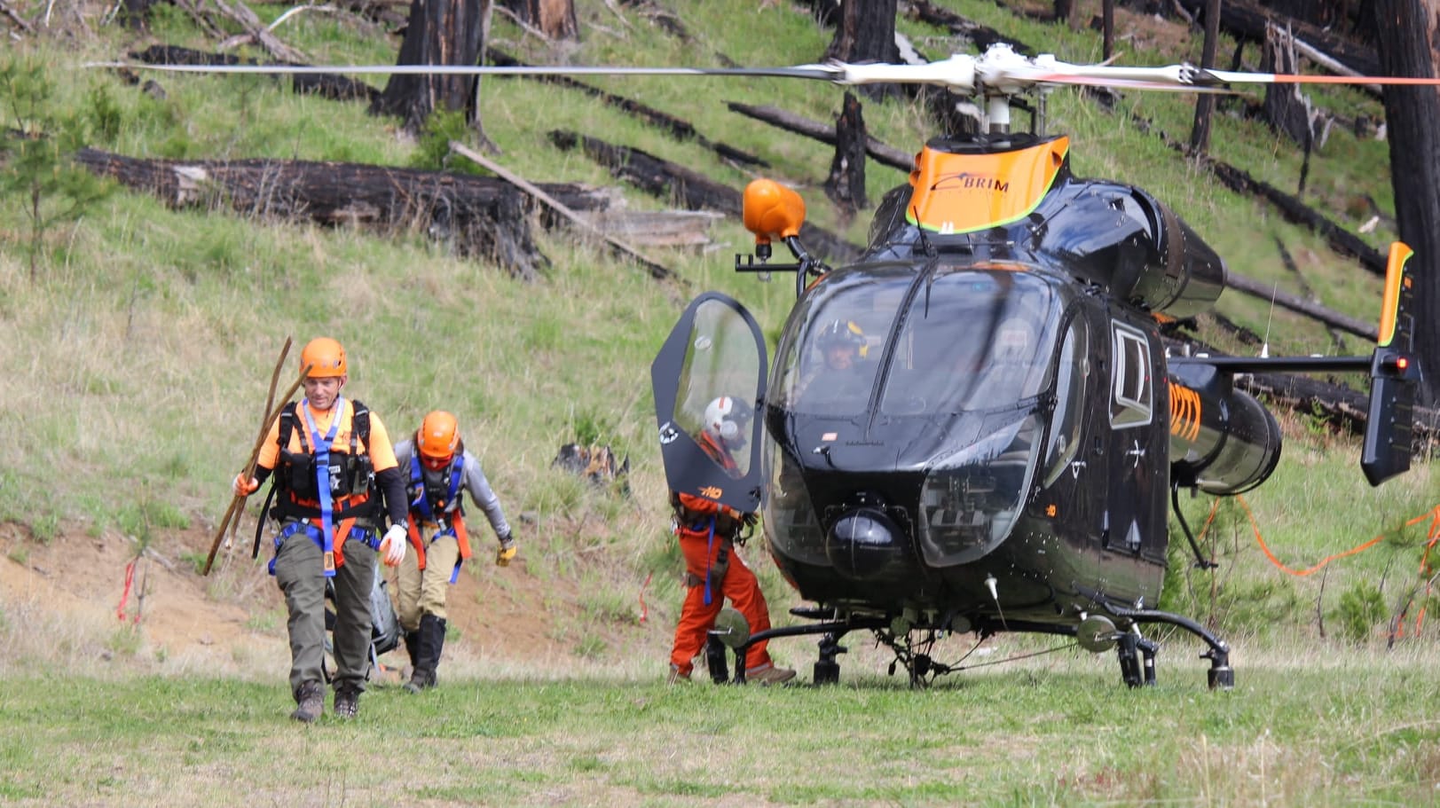 Rettungskräfte vor einem Helikopter: Suchtrupps hinterließen Nahrung und kleine Botschaften an den Waldwegen.