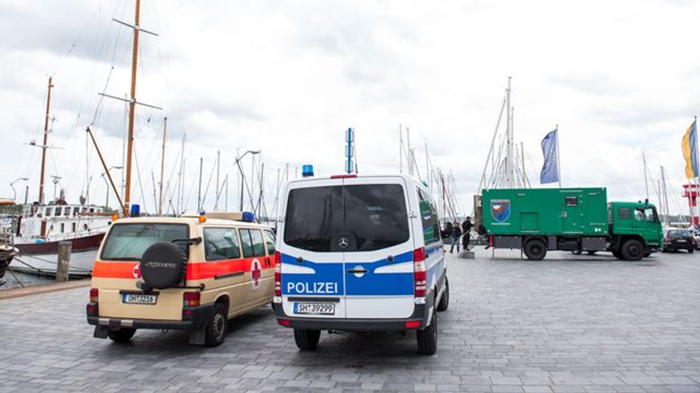 Die Fahrzeuge der Polizeitaucher stehen am Hafen: Ein Bekannter soll dort Waffenteile für den mutmaßlichen Schützen versenkt haben.