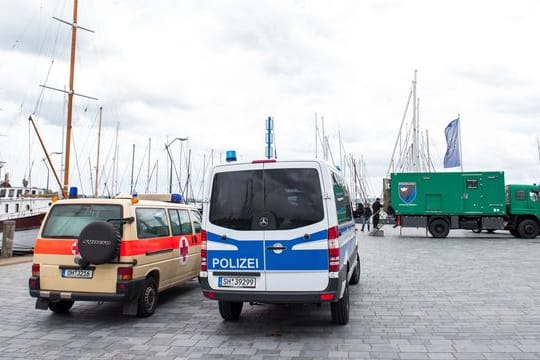 Die Fahrzeuge der Polizeitaucher stehen am Hafen: Ein Bekannter soll dort Waffenteile für den mutmaßlichen Schützen versenkt haben.