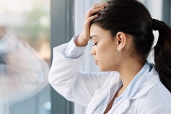 Erschöpft wirkende medizinische Fachkraft: Mit Burn-out war ursprünglich die Folge von arbeitsbedingtem Stress bei Menschen in helfenden Tätigkeiten gemeint.