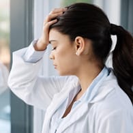 Erschöpft wirkende medizinische Fachkraft: Mit Burn-out war ursprünglich die Folge von arbeitsbedingtem Stress bei Menschen in helfenden Tätigkeiten gemeint.