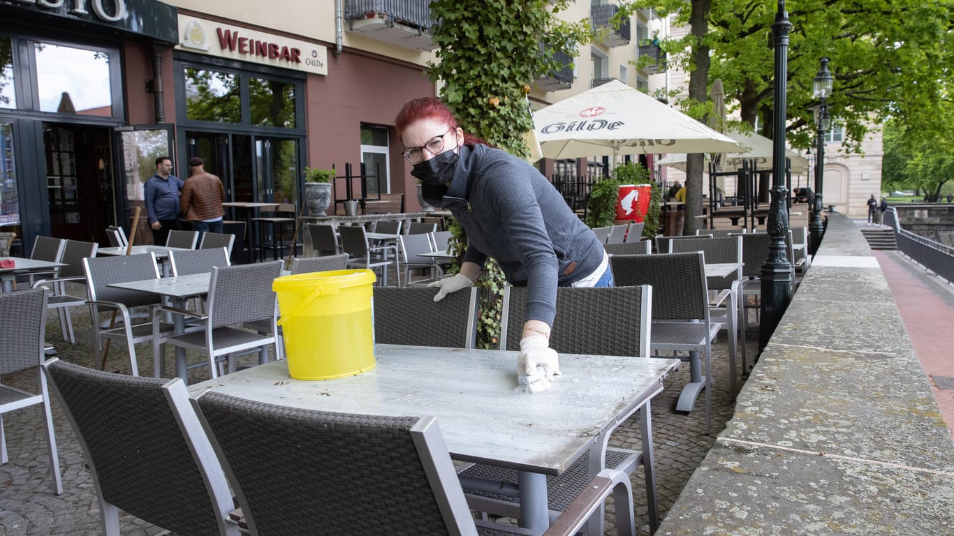Eine Servicekraft wischt einen Tisch ab (Symbolbild): Auch in Stuttgart dürfen nun viele Betriebe wieder öffnen.