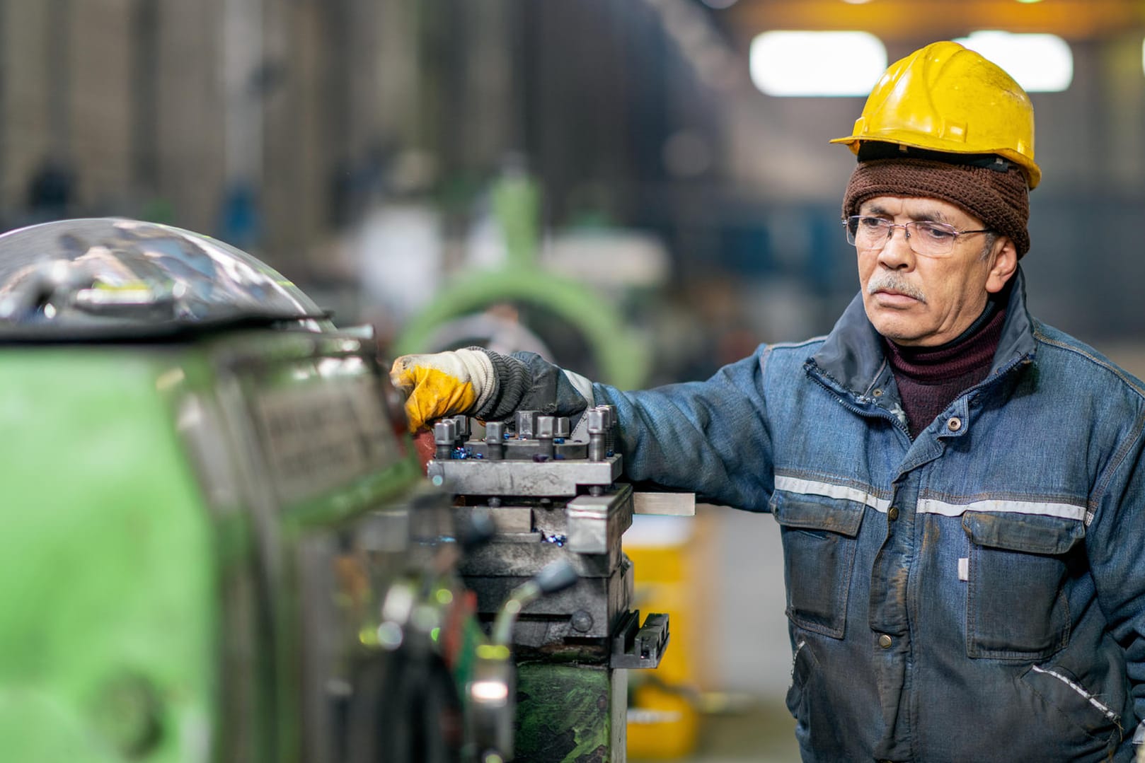 Älterer Arbeiter bedient eine Maschine (Symbolbild): Eine Betriebsrente kann Ihre gesetzliche Rente aufstocken.