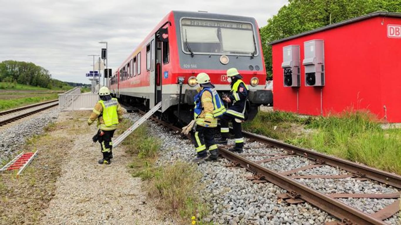 Feuerwehrleute sind an einem Regionalzug im Einsatz, nachdem dieser eine 14-Jährige erfasst hatte: Das Mädchen war zum Zug gerannt und auf die Gleise gestürzt.