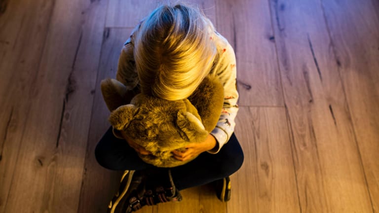 Kindesmissbrauch: Ein Mädchen versteckt ihr Gesicht in einem Teddybär und sucht Trost.