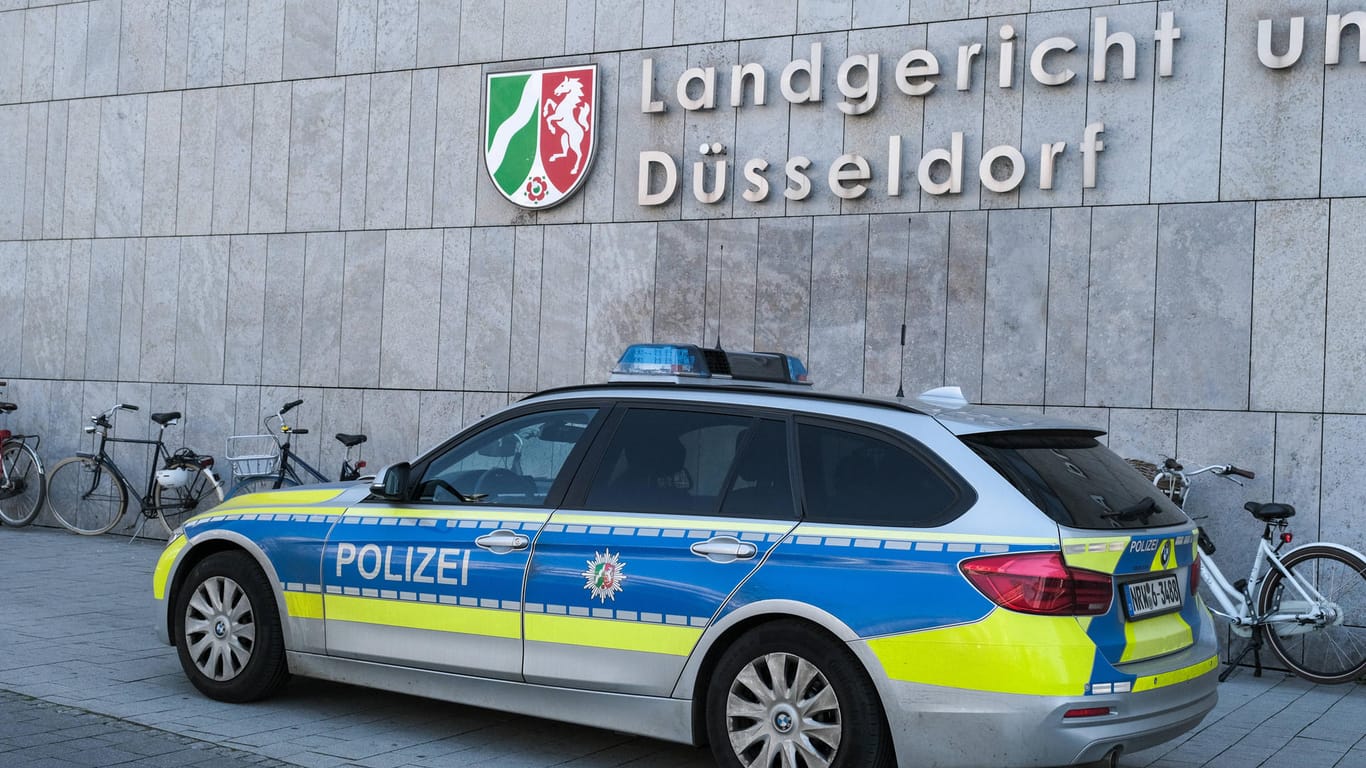 Ein Polizeiwagen steht vor dem Düsseldorfer Landgericht (Symbolbild): Der Angeklagte sitzt seit mehreren Monaten in Untersuchungshaft.
