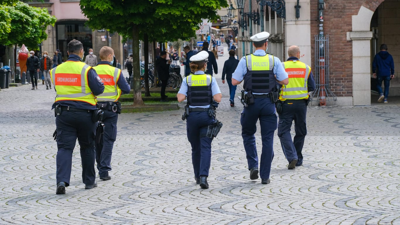 Polizisten und Mitarbeiter des Ordnungsamtes laufen durch die Düsseldorfer Altstadt (Archivbild): Hier war es zu zahlreichen Verstößen gegen die Corona-Maßnahmen gekommen.