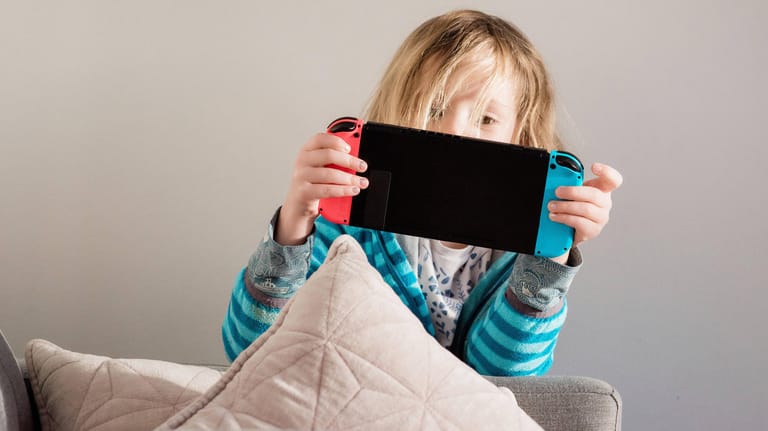 Ein Mädchen spielt mit einer Switch-Konsole (Symbolbild): Nintendo soll Herbst den Verkaufsstart einer neuen Version der beliebten Nintendo Switch planen.