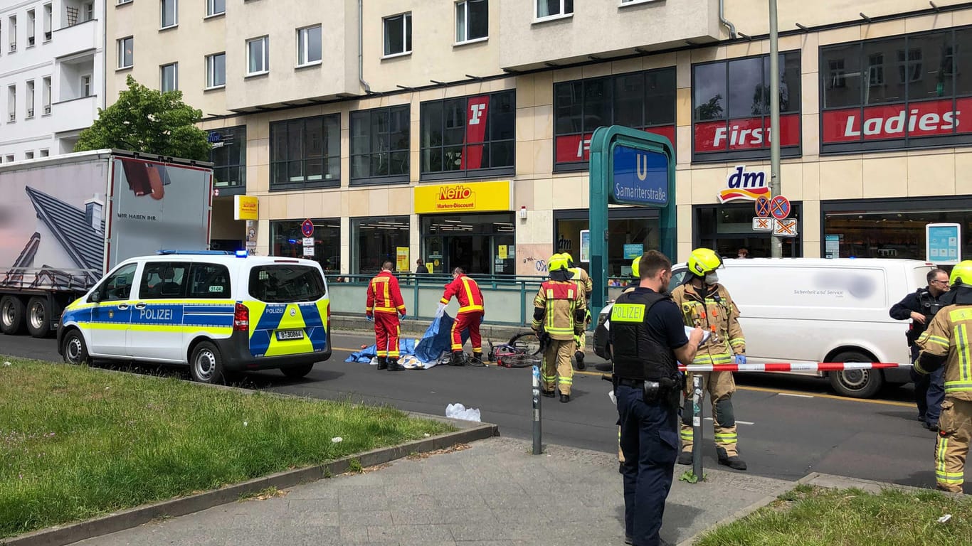 Berlin: Mit Tüchern bedecken Rettungskräfte die Radfahrerin, die bei einem Unfall auf der Frankfurter Allee im Stadtteil Friedrichshain tödlich verletzt wurde.