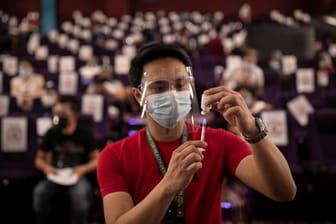 Ein Mitarbeiter bereitet eine Corona-Impfung in einem Kino in Manila vor: Auf den Philippinen sind viele Menschen skeptisch gegenüber der Vakzine.