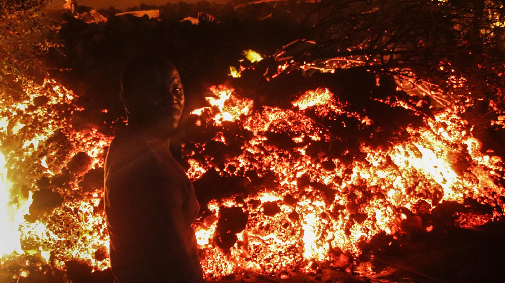 Eine Person steht vor der Lava des Nyiragongo am Stadtrand von Goma: Nach fast zwei Jahrzehnten war der Vulkan am vergangenen Wochenende wieder ausgebrochen.