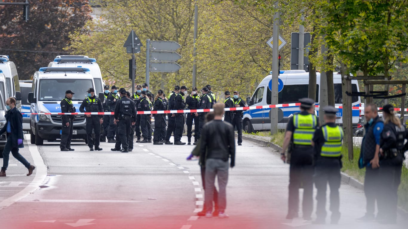 Polizisten stehen neben ihren Fahrzeugen nahe dem abgesperrten Tatort: Ein Mann ist bei einem Polizeieinsatz in Hamburg-Winterhude erschossen worden.