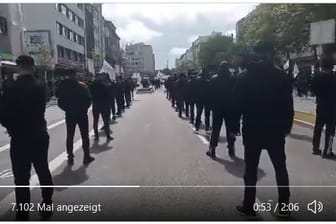 Schwarz gekleidete Personen stehen auf dem Hamburger Steindamm: Sie haben unter anderem antisemitische Parolen gerufen.