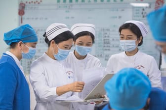 Krankenpflegerinnen in Wuhan beraten die Diagnose eines Corona-Patienten (Archivbild). Die WHO warnt vor voreiligen Schlüssen bei der Suche nach dem Ursprung des Virus.