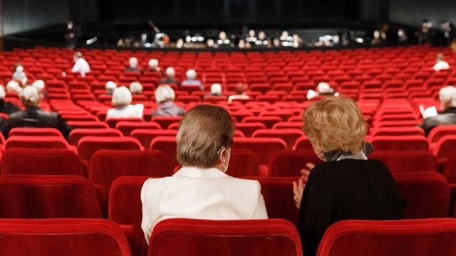 Besucher sitzen mit großen Abständen zueinander in der Staatsoper