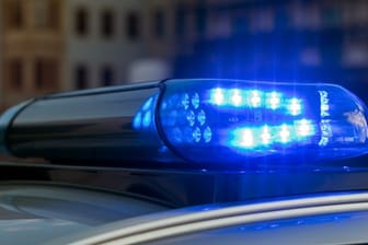 Blaulicht eines Streifenwagens: Zwei Männer und eine Frau sind festgenommen worden, mindestens ein Täter ist noch auf der Flucht.