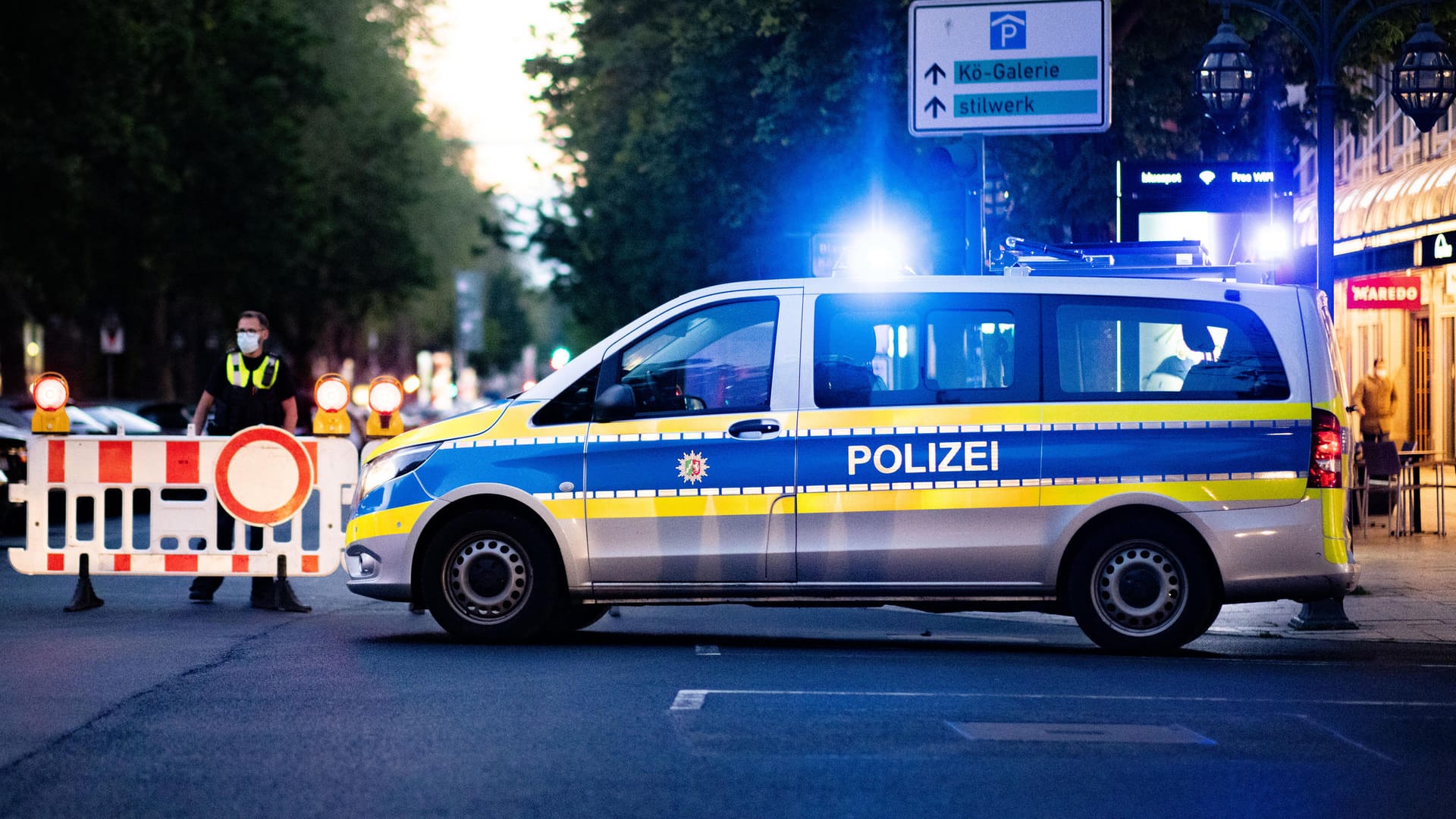 Ein Polizist errichtet Absperrungen auf der Königsallee. Nach massiven Verstößen gegen Corona-Auflagen in der Düsseldorfer Innenstadt wird die Königsallee als Maßnahme gegen die Autoposer-Szene am Abend erstmals gesperrt. Ein Polizist errichtet Absperrungen auf der Königsallee. Nach massiven Verstößen gegen Corona-Auflagen in der Düsseldorfer Innenstadt wird die Königsallee als Maßnahme gegen die Autoposer-Szene am Abend erstmals gesperrt.