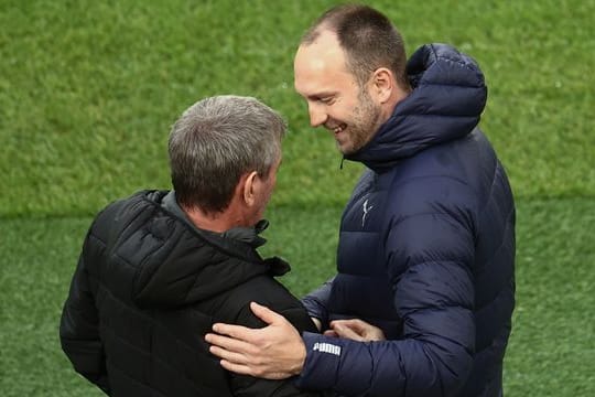 Kiels Trainer Ole Werner (r) begrüßt Kölns Trainer Friedhelm Funkel.