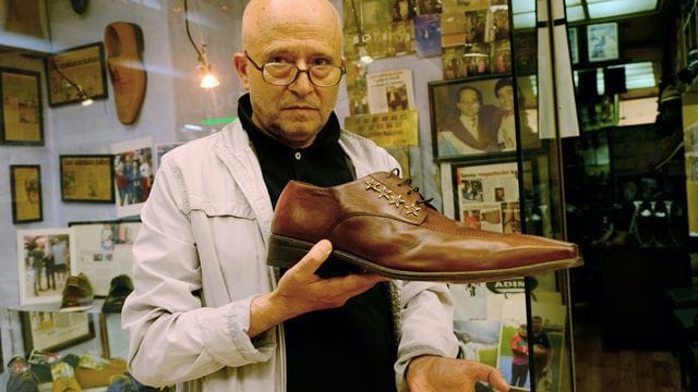 Schuster Öncel Kalkan zeigt vor seinem Laden den größten Schuh, den er produziert hat - er ist 57 Zentimeter lang.