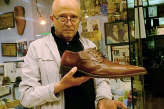 Schuster Öncel Kalkan zeigt vor seinem Laden den größten Schuh, den er produziert hat - er ist 57 Zentimeter lang.