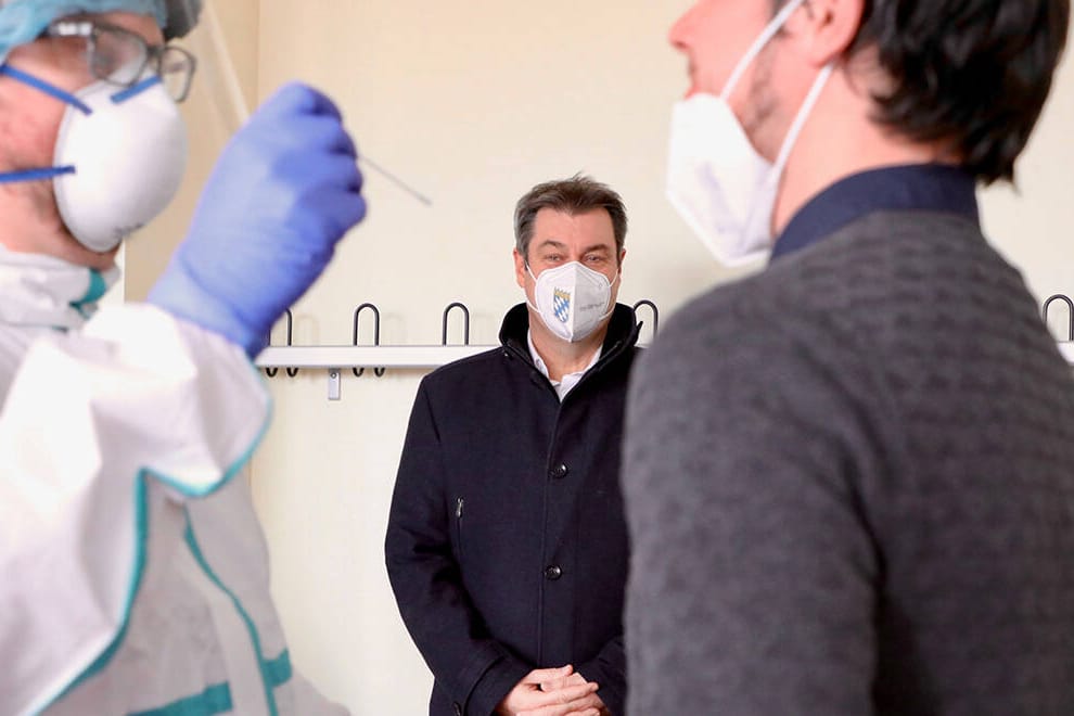 Mitarbeiter der Teststation stellen Bayerns Ministerpräsident Söder den Testablauf mit einem Beispiels-Test vor: Ein möglicher Abrechnungsbetrug bei Bürgertests zieht seit dem Wochenende immer weitere Kreise.