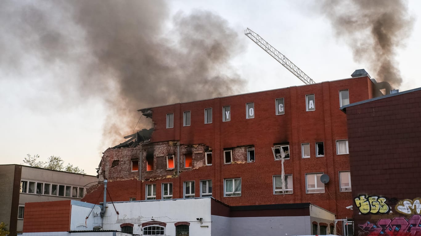 Rauch zieht über ein explodiertes Gebäude in Hamburg-Barmbek: Die Explosion des Gebäudes in hat einen Großeinsatz der Feuerwehr ausgelöst.