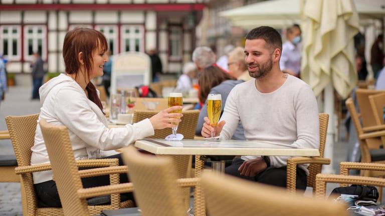Sachsen-Anhalt, Wernigerode: Gäste sitzen in einem Straßencafe am Marktplatz.