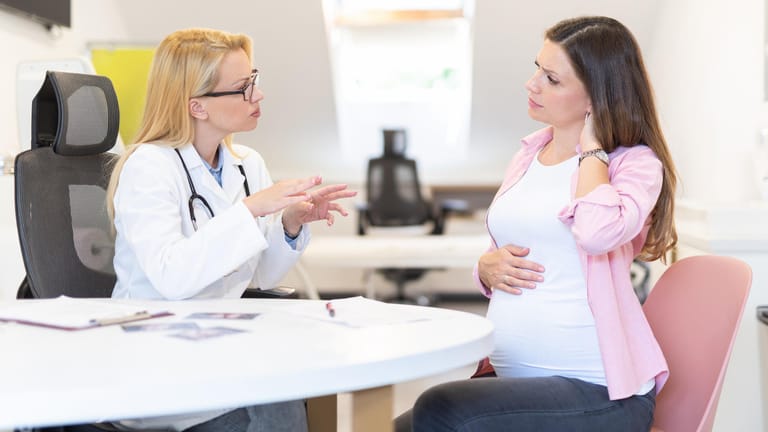 Eine Schwangere im Gespräch mit einer Ärztin: Ein Scheidenpilz in der Schwangerschaft sollte behandelt werden.