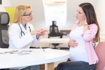 Eine Schwangere im Gespräch mit einer Ärztin: Ein Scheidenpilz in der Schwangerschaft sollte behandelt werden.