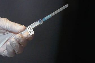 Eine Mitarbeiterin eines Impfteams überprüft eine Spritze mit dem Impfstoff gegen Covid-19 (Symbolbild): In Bayern können Menschen mit Vorerkrankungen einen Härtefallantrag für eine frühere Impfung stellen.