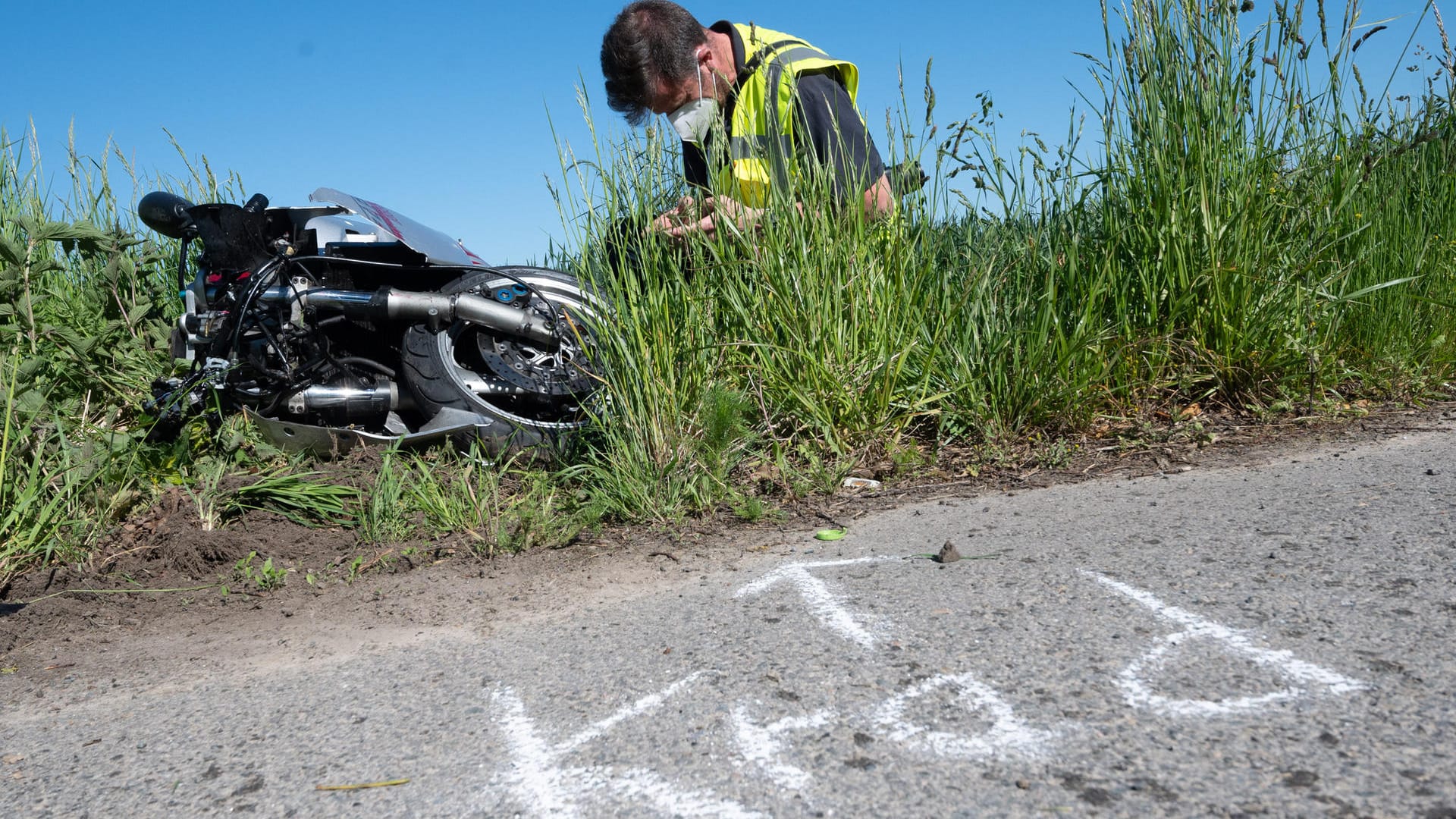 Ein Mitarbeiter der Verkehrsunfallforschung der Medizinischen Hochschule Hannover MHH hockt neben dem verunfallten Motorrad: Bei dem Unfall ist der Motorradfahrer mit einem abbiegenden Pkw kollidiert und dabei tödlich verletzt worden.