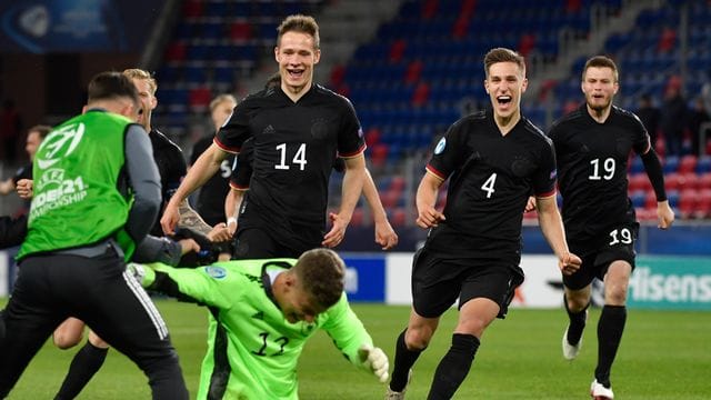 Die deutschen Spieler stürmen nach dem Sieg auf Torhüter Finn Dahmen zu.