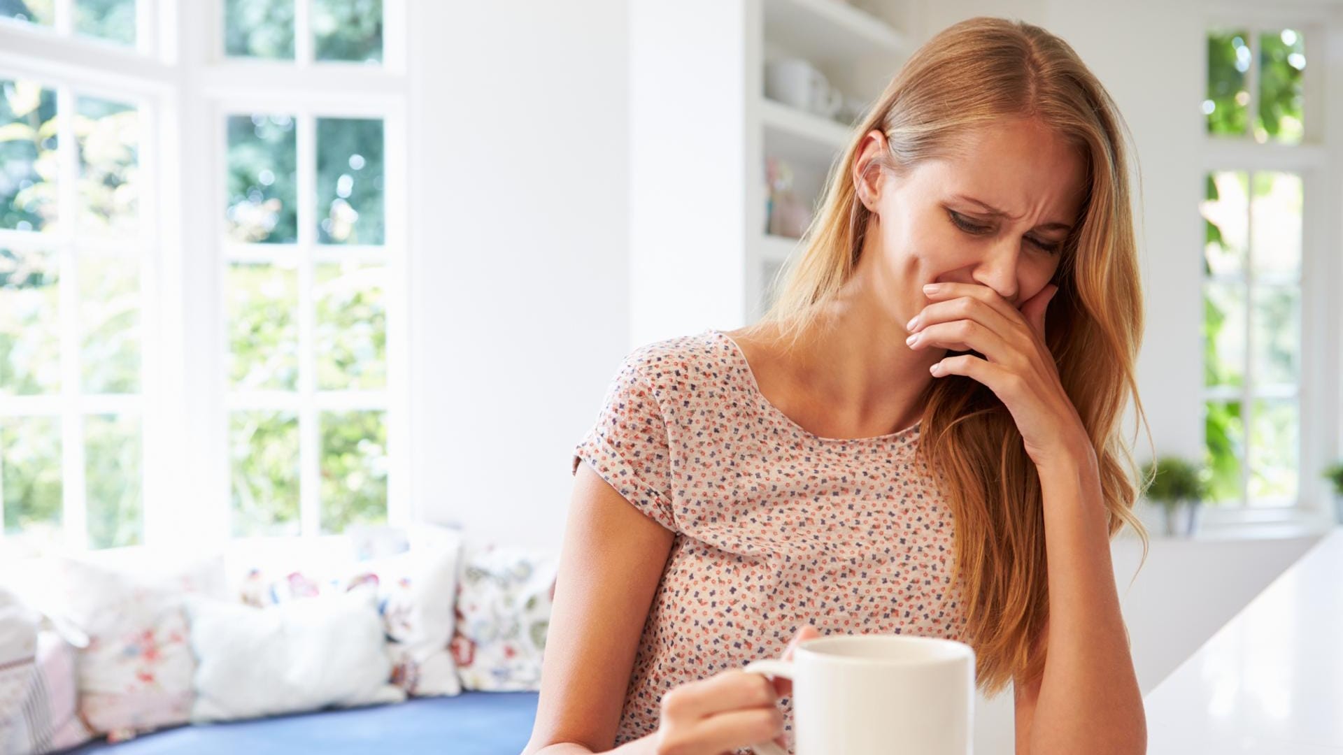 Frau verzieht das Gesicht wegen des Geruchs von Kaffee: Während der Schwangerschaft verändert sich der Geruchssinn. Angenehme Gerüche können plötzlich zu Übelkeit führen.