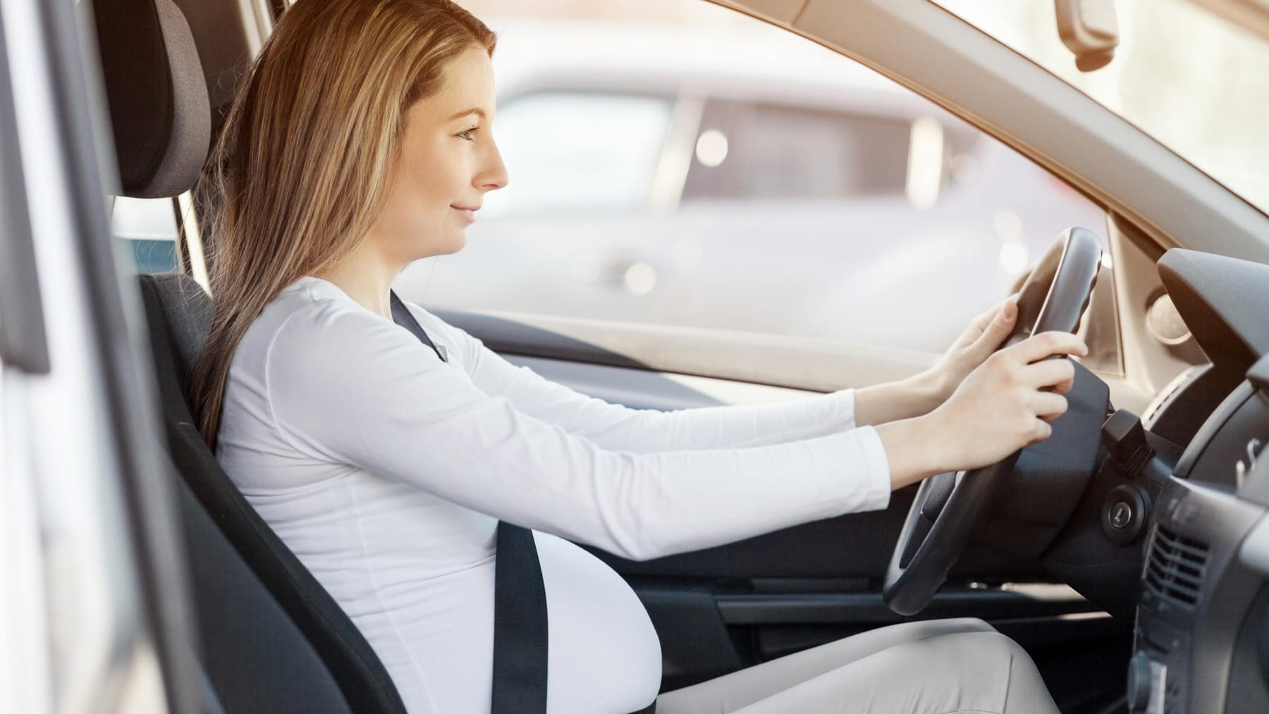 Eine schwangere Frau, die einen Sicherheitsgurt trägt, fährt ein Auto.  Sicherheit und Fahrverhalten während der Schwangerschaft, auf Reisen  Stockfotografie - Alamy