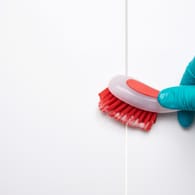 Spülbürste und Keramikfliesen: Mit Backpulver sollten Sie Ihre Fliesen und Fugen nicht reinigen.