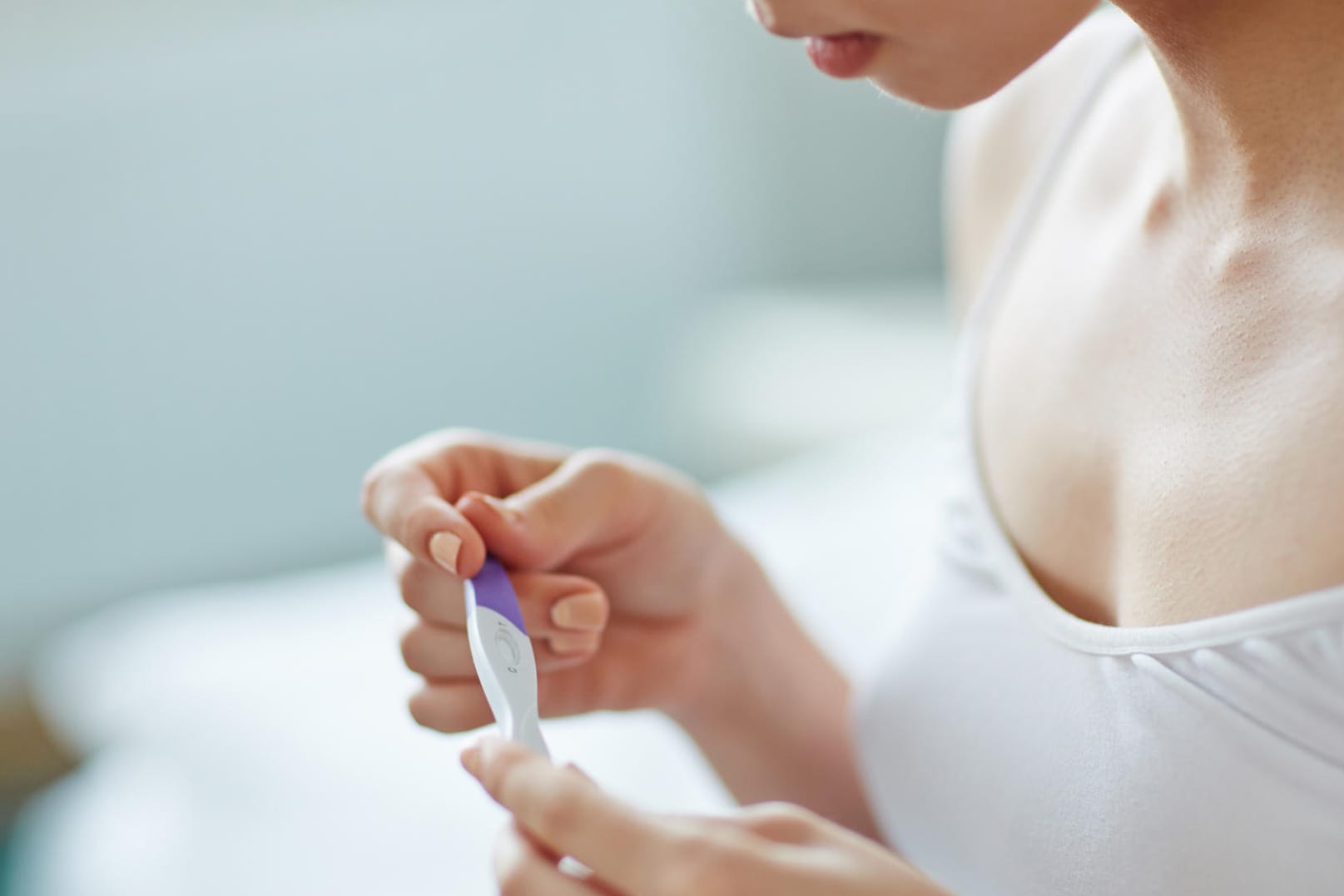 Eine junge Frau mit Schwangerschaftstest in der Hand: Ein Schwangerschaftstest kann Ihnen innerhalb von Sekunden anzeigen, ob Sie schwanger sind.