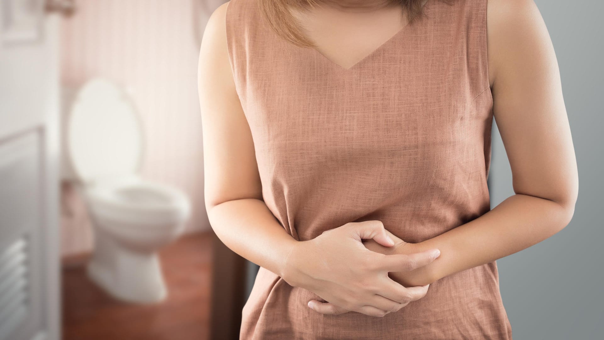 Frau hält sich den Bauch vor Schmerzen