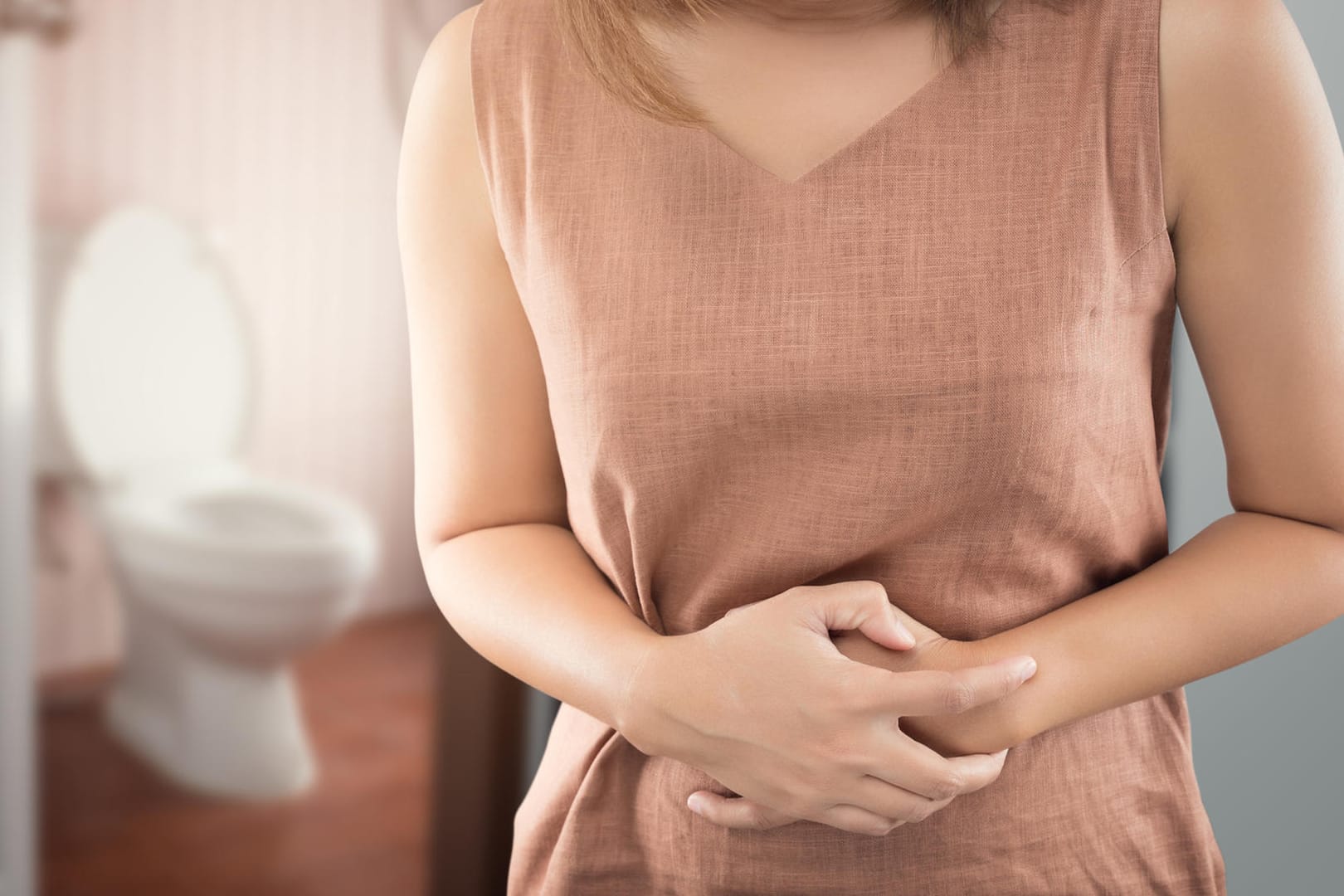 Frau hält sich den Bauch vor Schmerzen