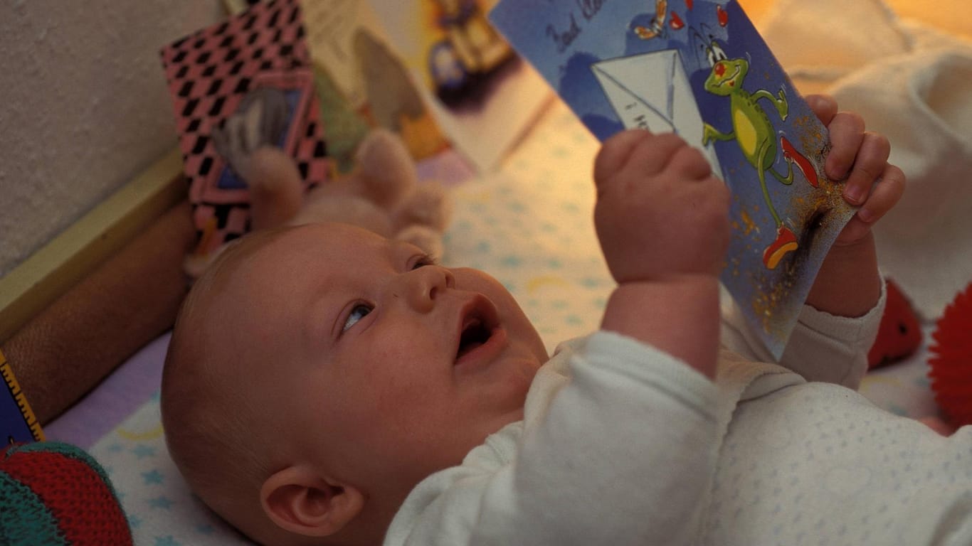 Baby mit Glückwunschkarte: Nicht nur die stolzen Eltern, auch der Nachwuchs freut sich über Post zur Geburt.