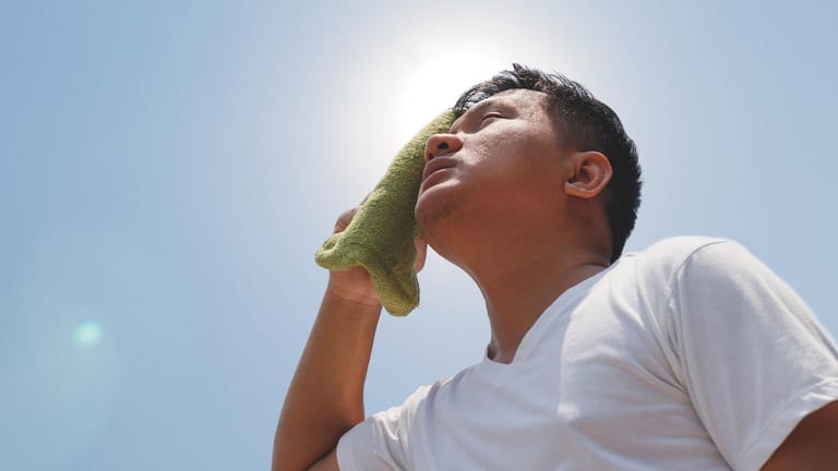 Mann schwitzt in der Sonne: Bei heißem Wetter ist die Gefahr groß, einen Hitzschlag zu erleiden.