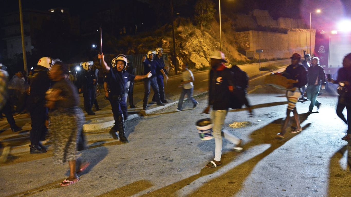 Polizisten bringen Menschen aus dem völlig überfüllten Migrantenlager auf der griechischen Insel Samos.
