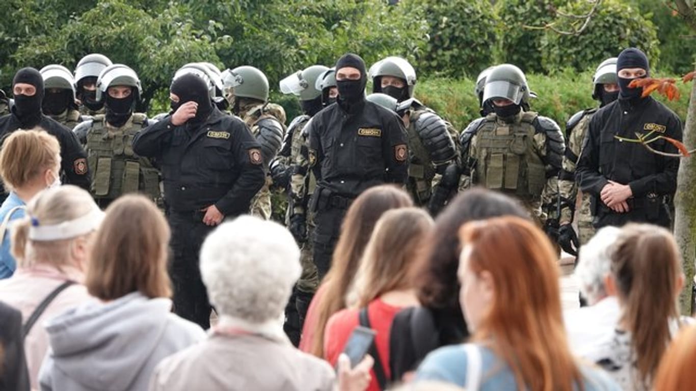 Demonstranten und Einsatzkräfte der Sonderpolizei OMON stehen sich am Unabhängigkeitsplatz in Minsk gegenüber.