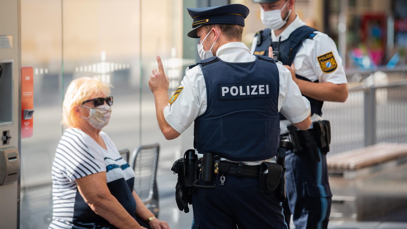 Polizisten ahnden einen Verstoß gegen die Maskenpflicht in Würzburg: 77 Prozent der Bundesbürger wünschen sich stärkere Kontrollen.