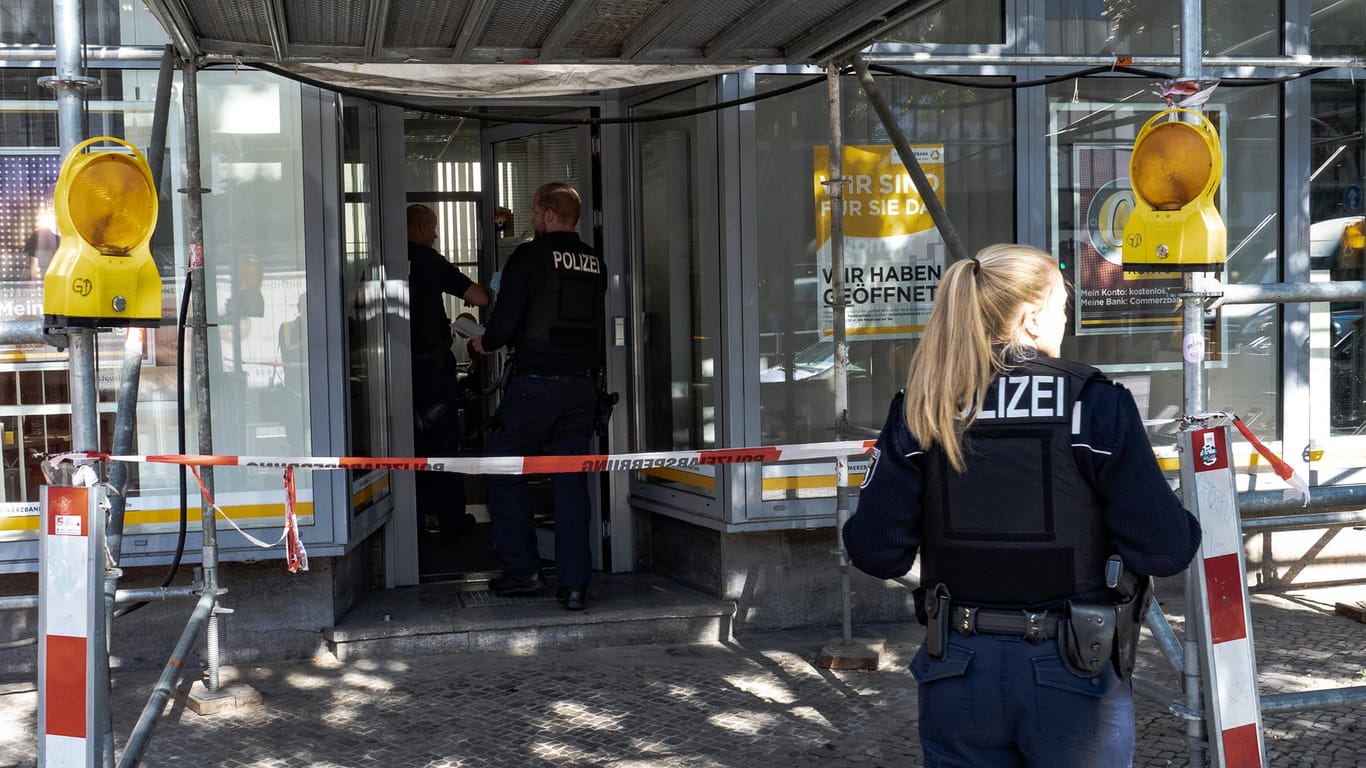 Eine Polizistin steht vor dem Eingang einer Bank: In Berlin haben sich zwei Banküberfälle an einem Tag ereignet.