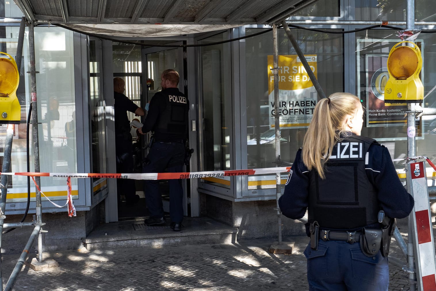 Eine Polizistin steht vor dem Eingang einer Bank: In Berlin haben sich zwei Banküberfälle an einem Tag ereignet.