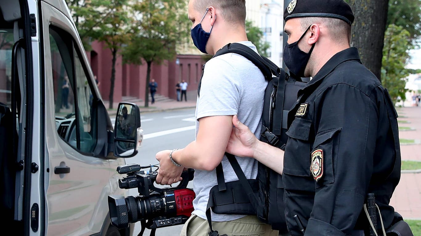 Minsk vor einem Monat: Eine Journalist wird von der Polizei festgenommen und in ein Auto gebracht.
