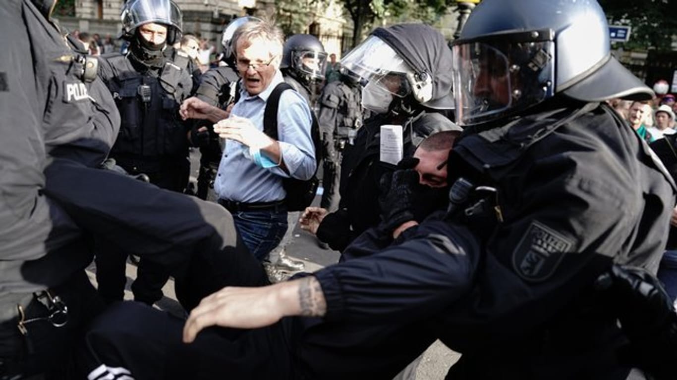 Die Polizei trägt einen Teilnehmer der Demonstration gegen die Corona-Maßnahmen in der Berliner Innenstadt weg.