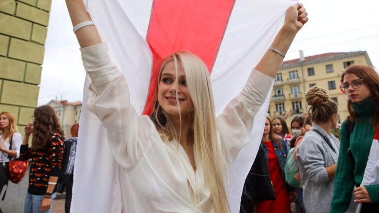 Eine Demonstrantin in Minsk reckt die belarussische Fahne: Der Protest gegen Machthaber Lukaschenko wird vor allem von Frauen getragen.
