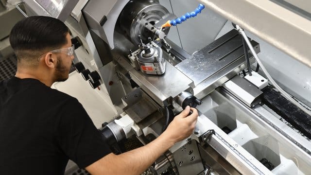 Der angehende Industriemechaniker Mohammed Elosrouti bearbeitet an der Drehmaschine ein Werkstück.